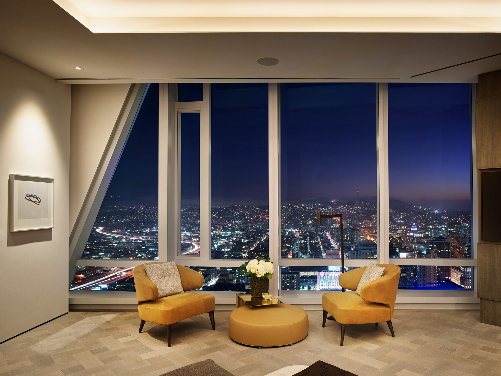 Grand Penthouse Primary Bedroom Sitting Area at Night with City Lights in View